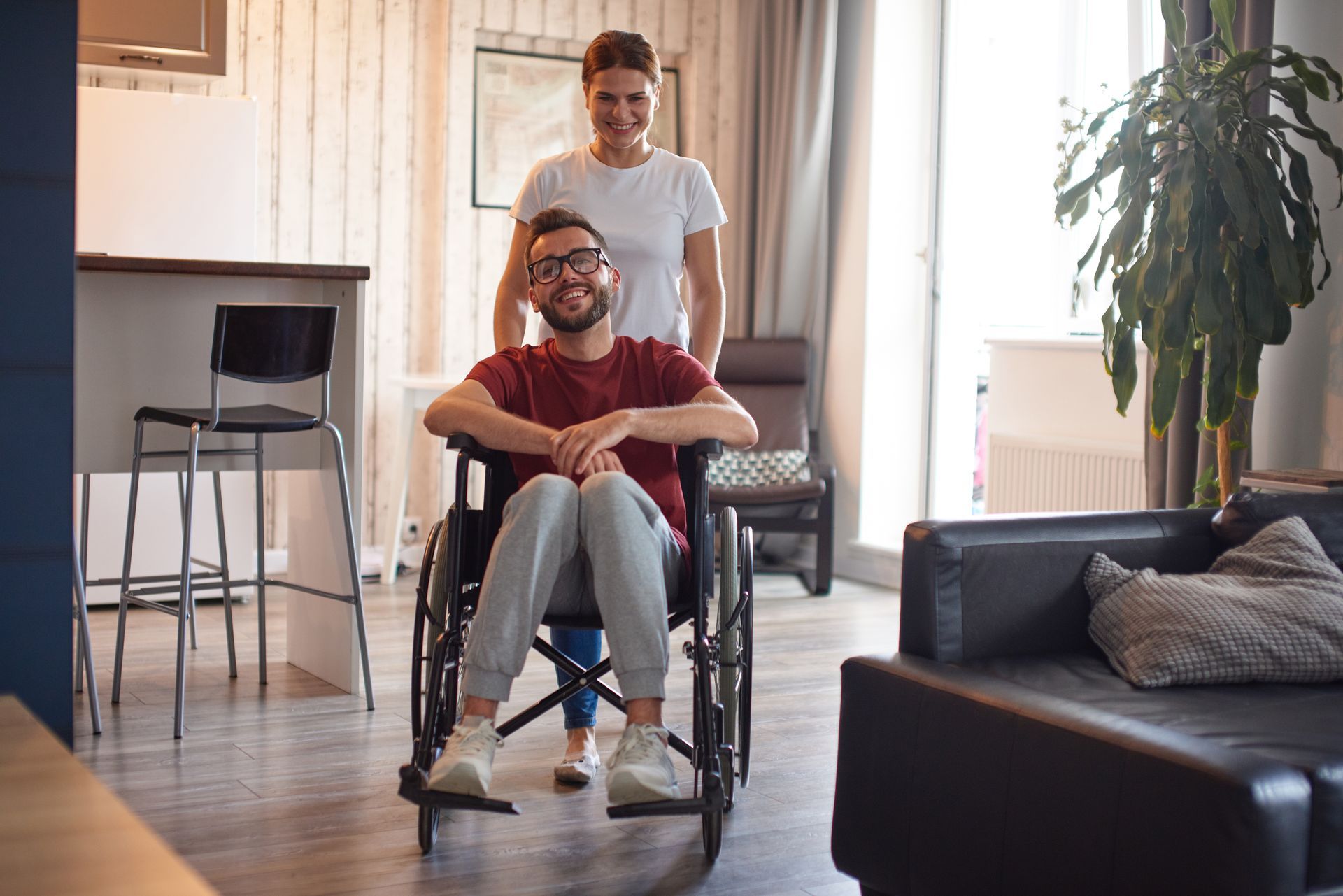 Un jeune homme en fauteuil roulant et une jeune femme en arrière-plan.