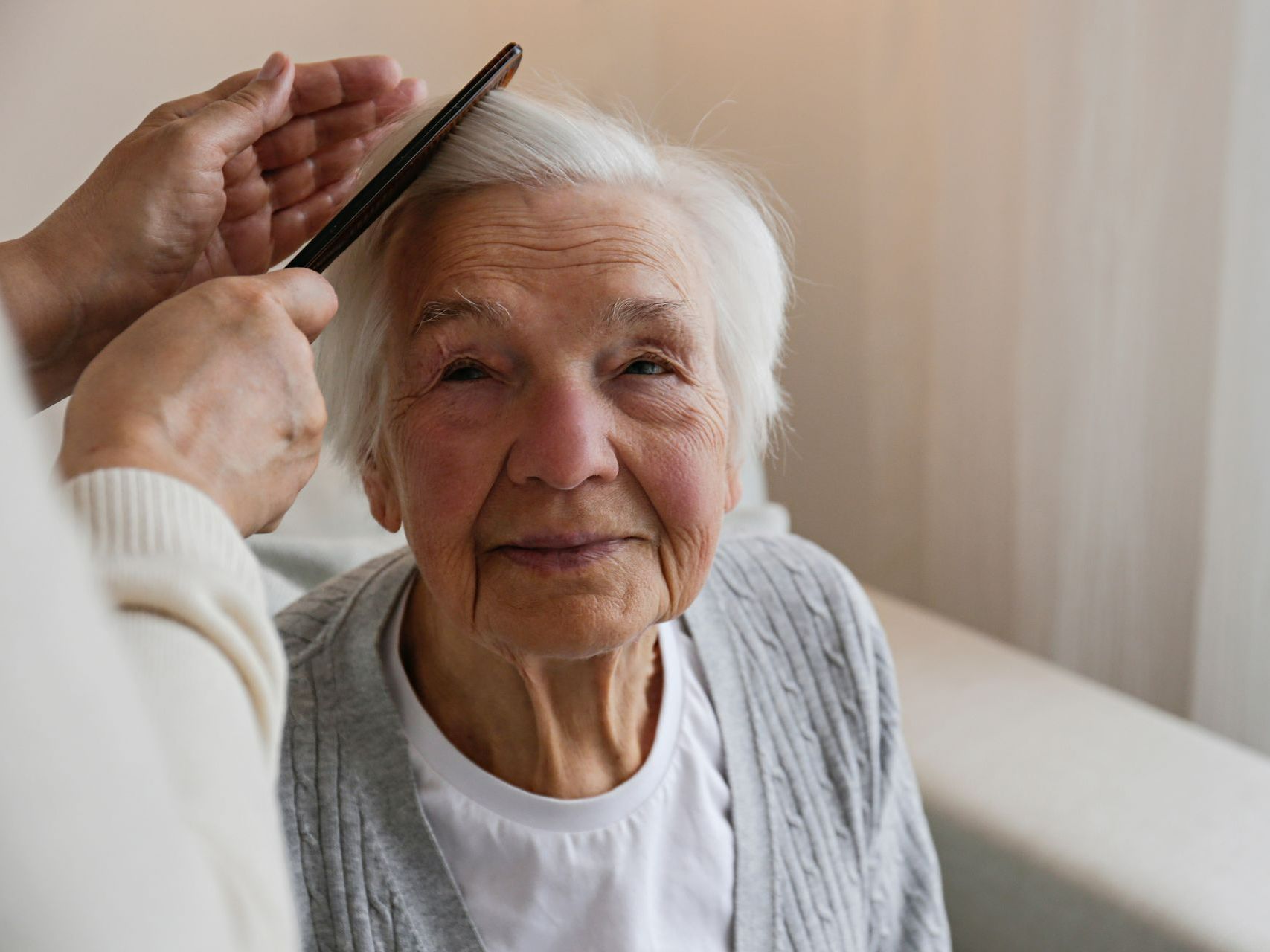 Une femme âgée qui se fait coiffer.