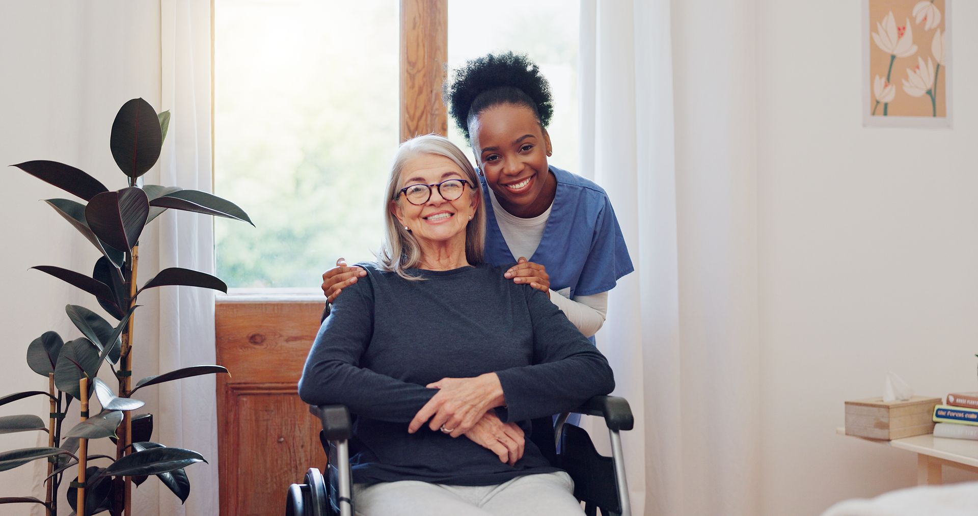 Une femme âgée en fauteuil roulant et une auxiliaire de vie.