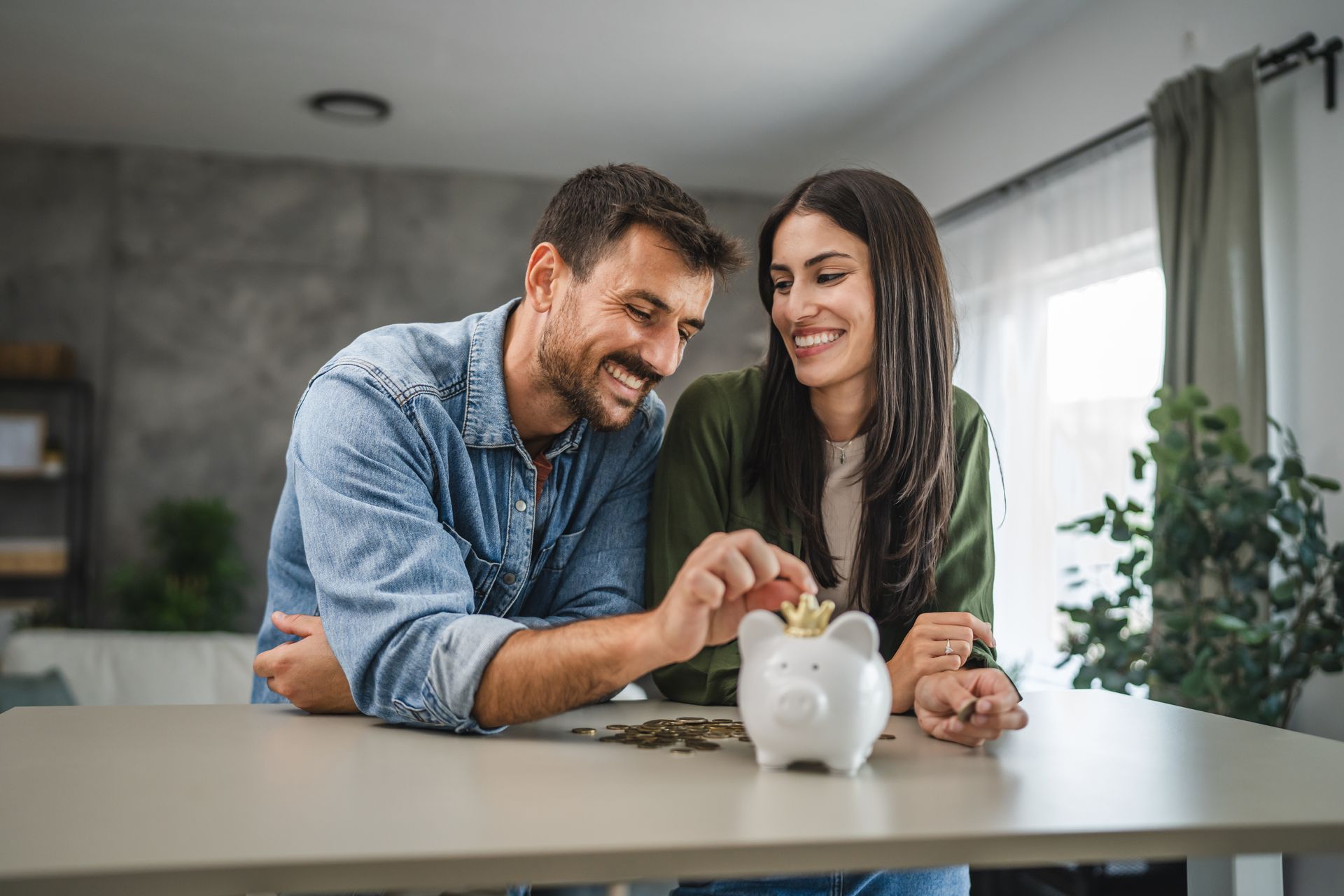 Un couple avec une tirelire en premier plan.