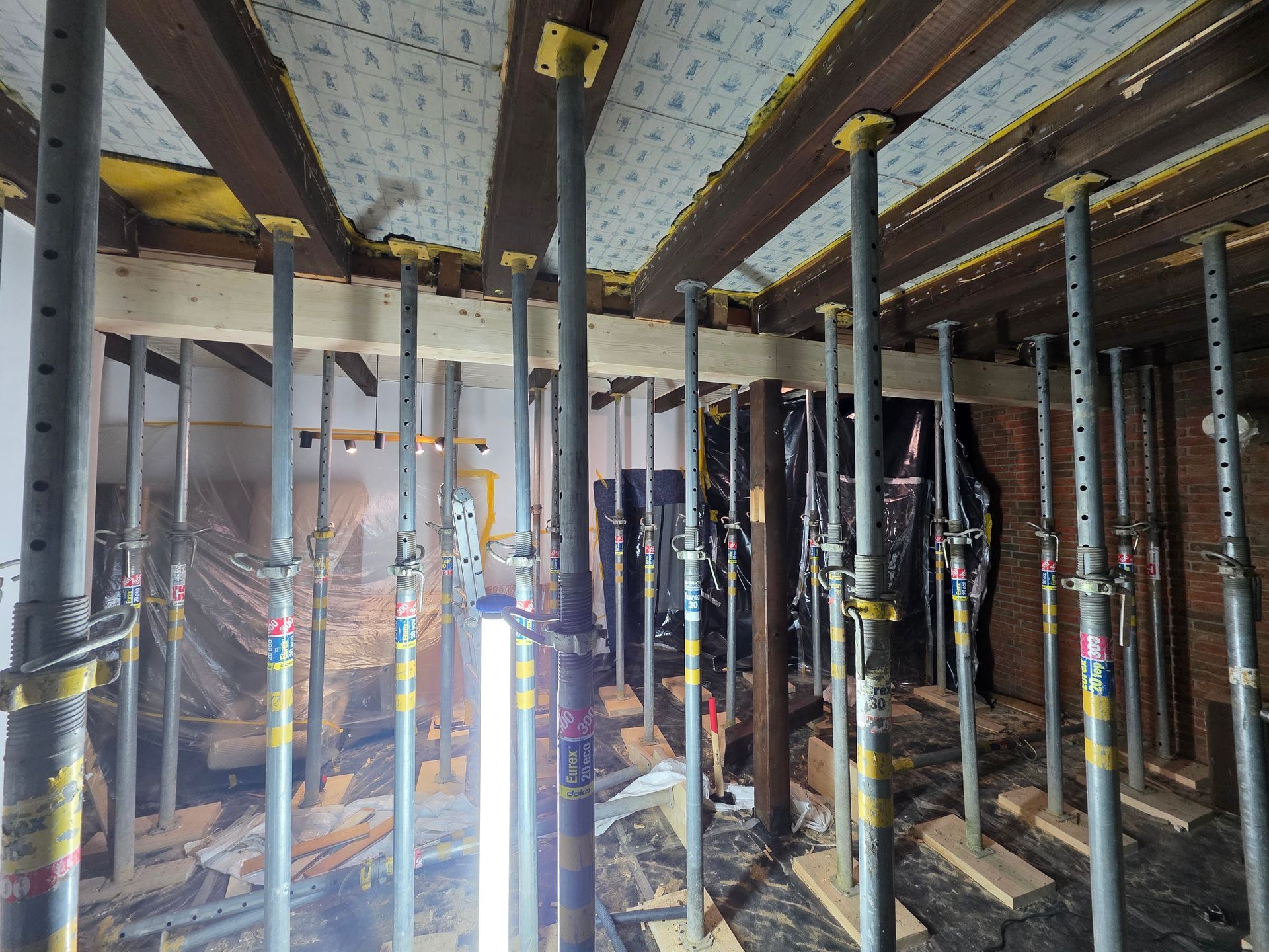 Innenansicht einer Baustelle. Metallträger stützen die Decke; der Raum ist komplett entkernt.