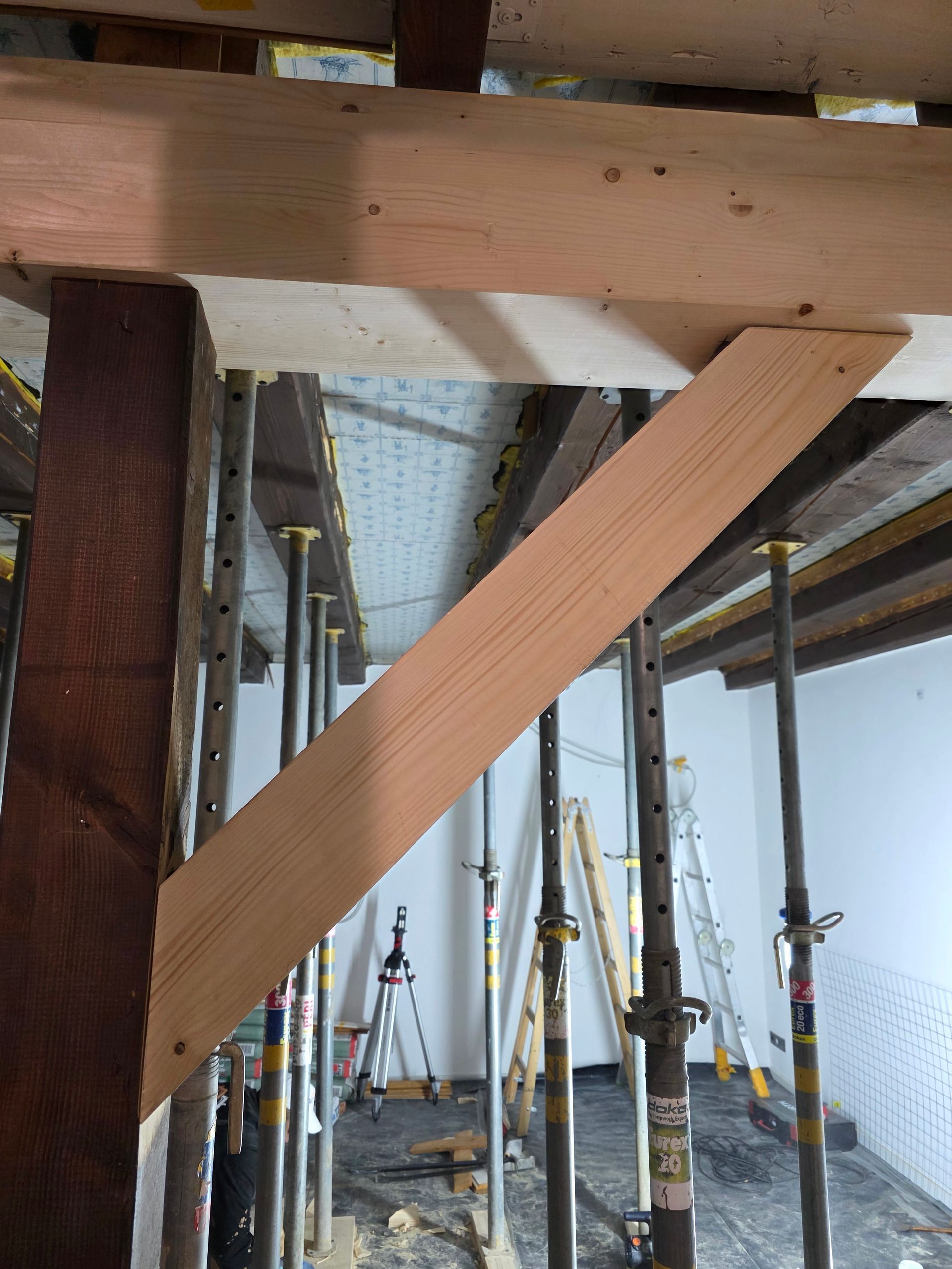 Die Decke ist mit Holzträgern versehen. Metallstangen dienen als Stützen.