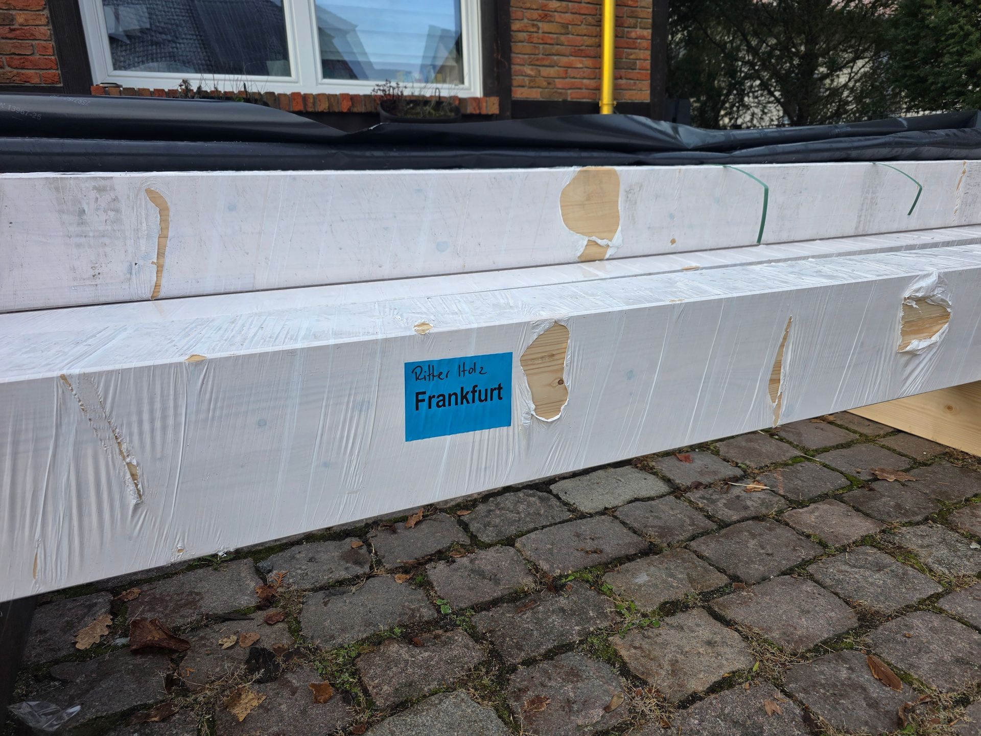 Weiße Schaumstoffplatten mit blauem „FortKing“-Etikett, gestapelt auf einer Ziegeloberfläche.