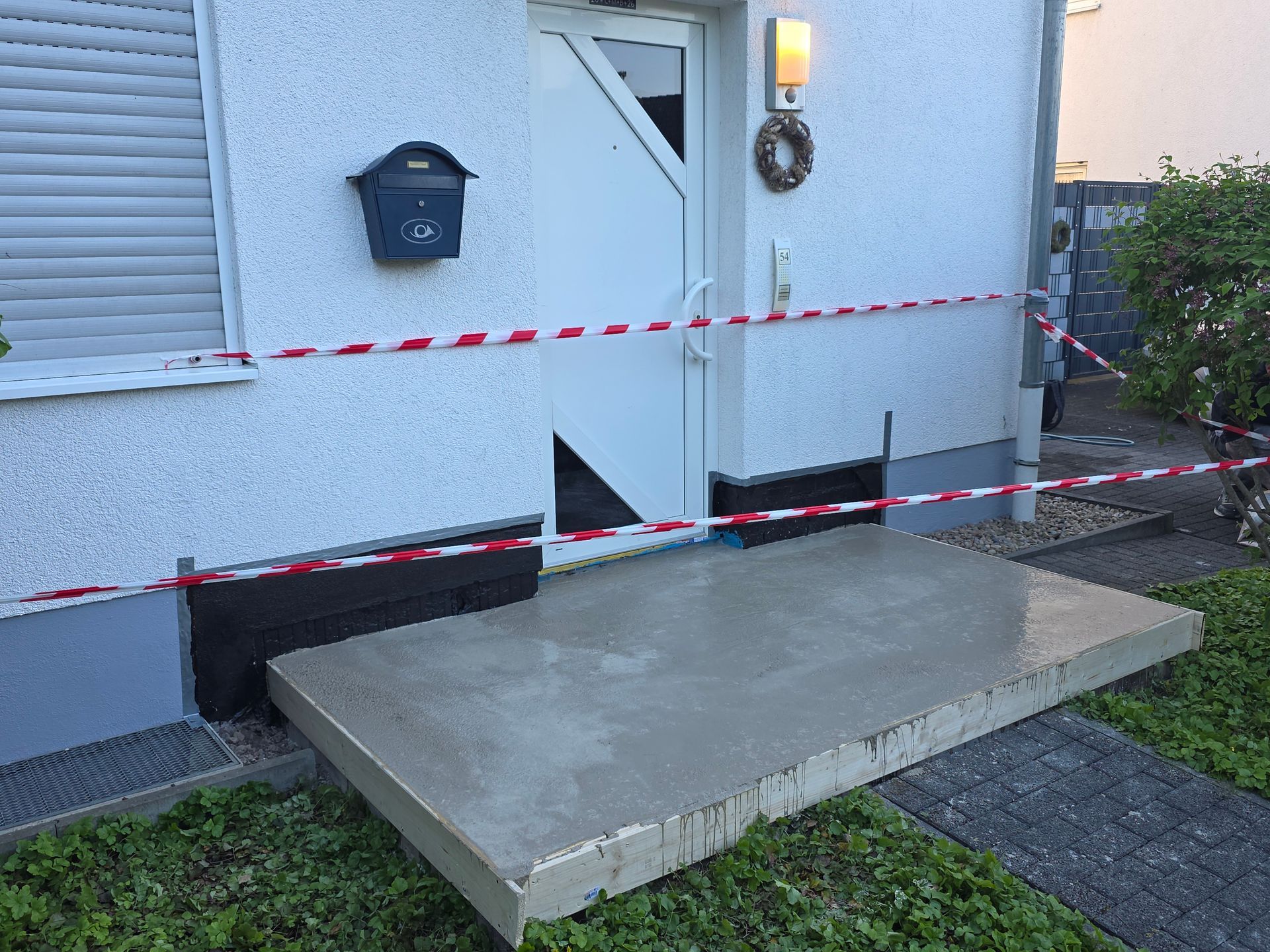 Risse in der Betontreppe und der Veranda wurden als Sicherheitsrisiko vor einem weißen Haus abgesperrt.