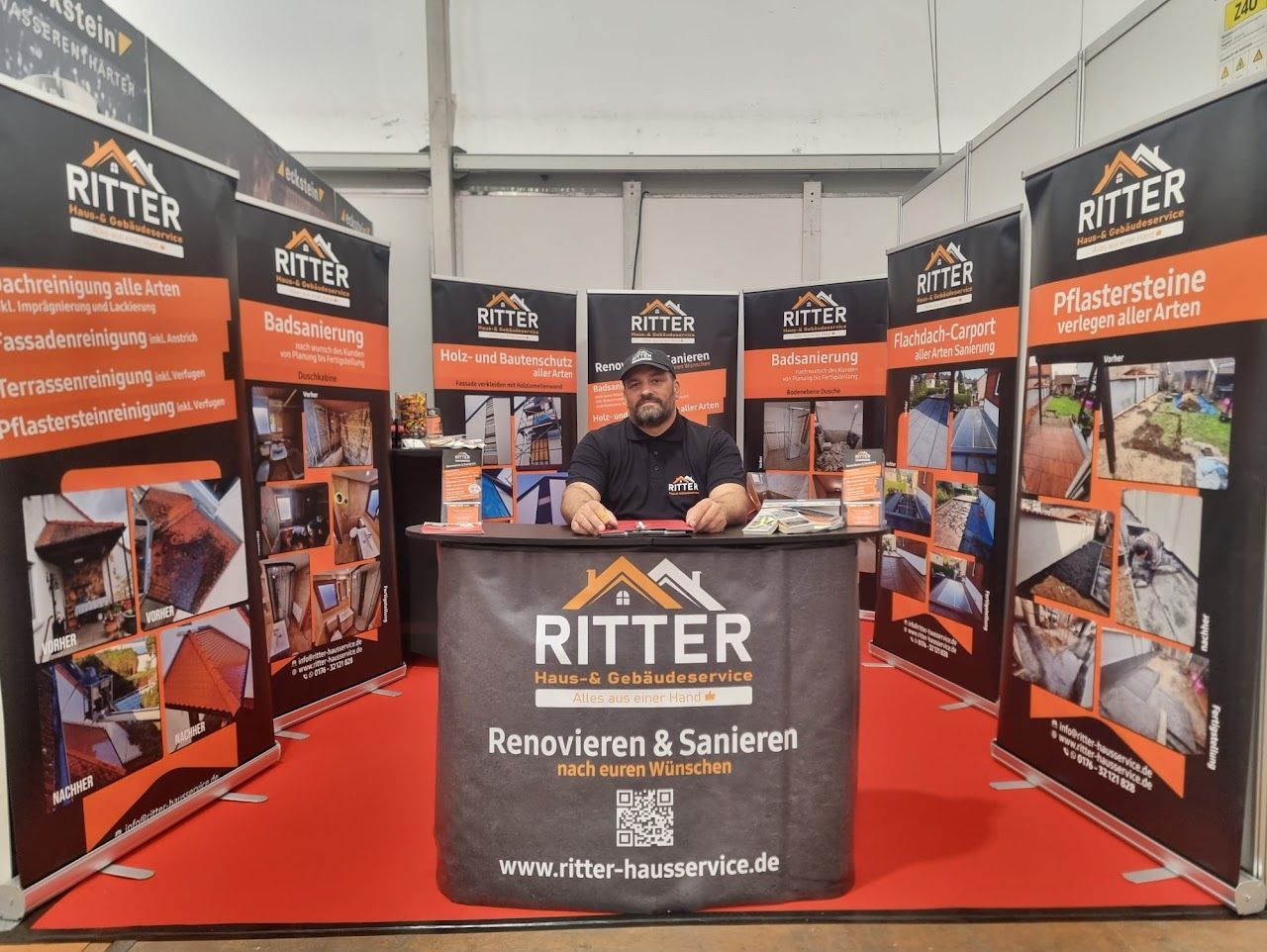 Ein Messestand von Ritter. Der Stand ist schwarz-orange und mit Produktabbildungen versehen. Der Mann lächelt in die Kamera.