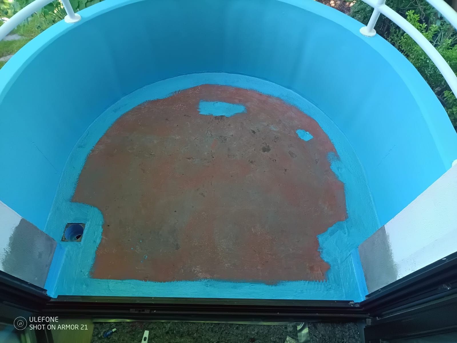 Blauer Hallensportplatz oder Schwimmbeckenboden mit braun aufgemaltem Halbkreis und weißen Markierungen