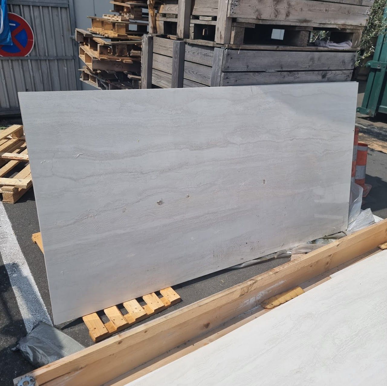 Große rechteckige graue Platte auf Holzstützen im Freien.