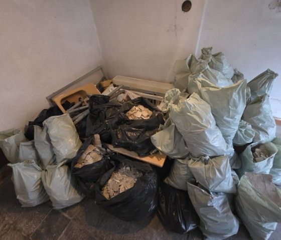 Ein Stapel Müllsäcke, einige schwarz, einige weiß, in einem Zimmer.