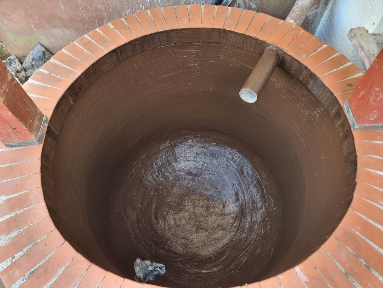 Rundes Backsteingebäude mit tiefem Innenraum und einem Rohr.