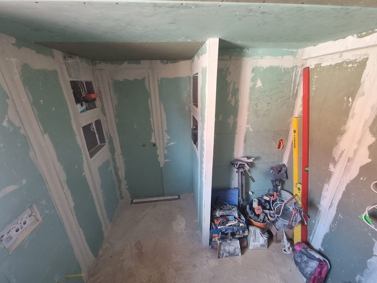 Innenausbau: Trockenbau-, und Maler- und Elektroarbeiten; Werkzeuge und Materialien sind sichtbar.