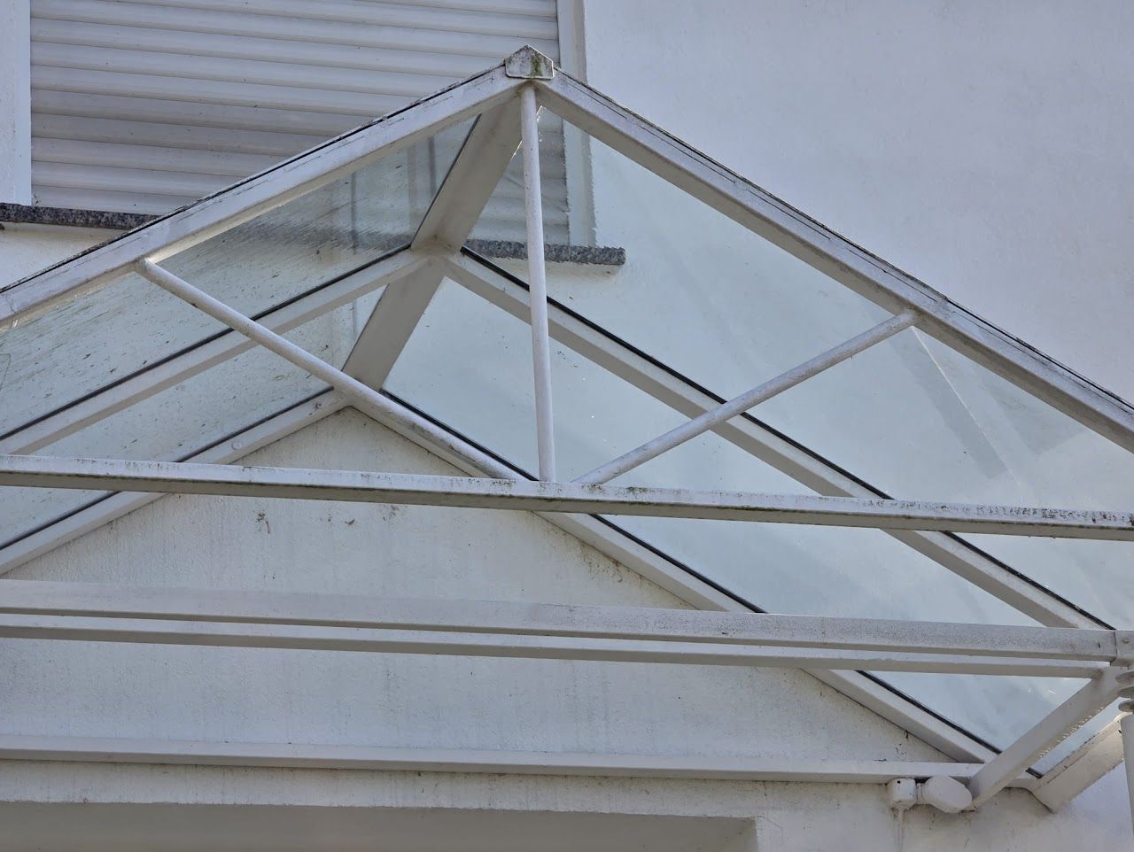 Eine weiße Glasmarkise über einem weißen Türrahmen.