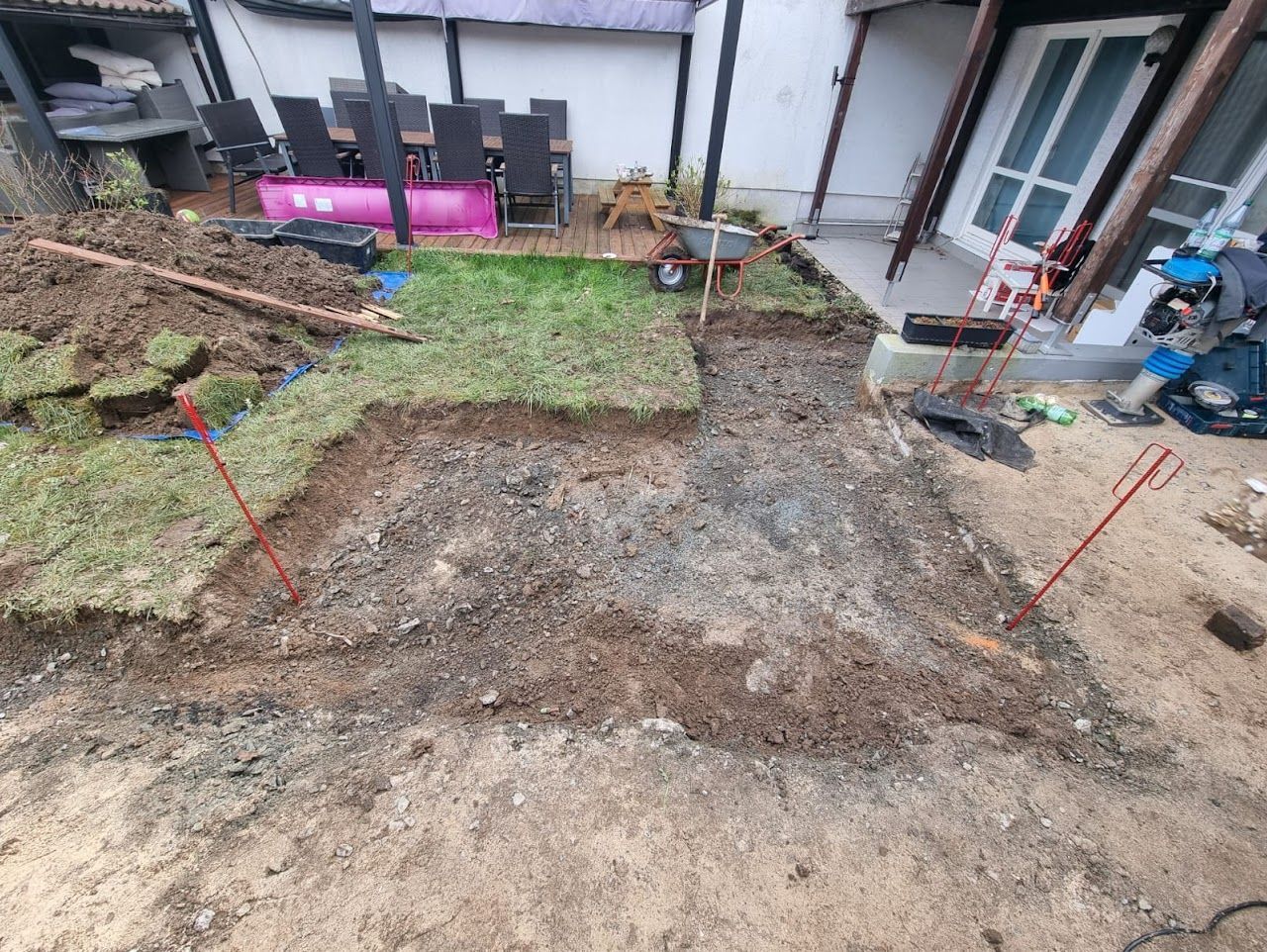 Gartenarbeiten im Hinterhof im Gange: Rasen entfernt, Fläche ausgehoben, Kiesweg angelegt.