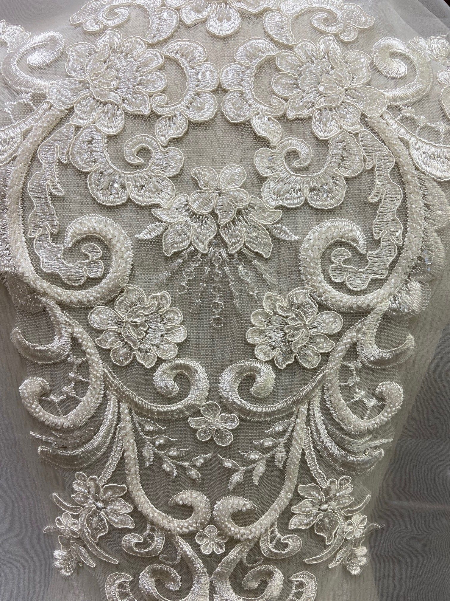 Eine Nahaufnahme eines Stücks Spitze mit einem Blumenmuster darauf.