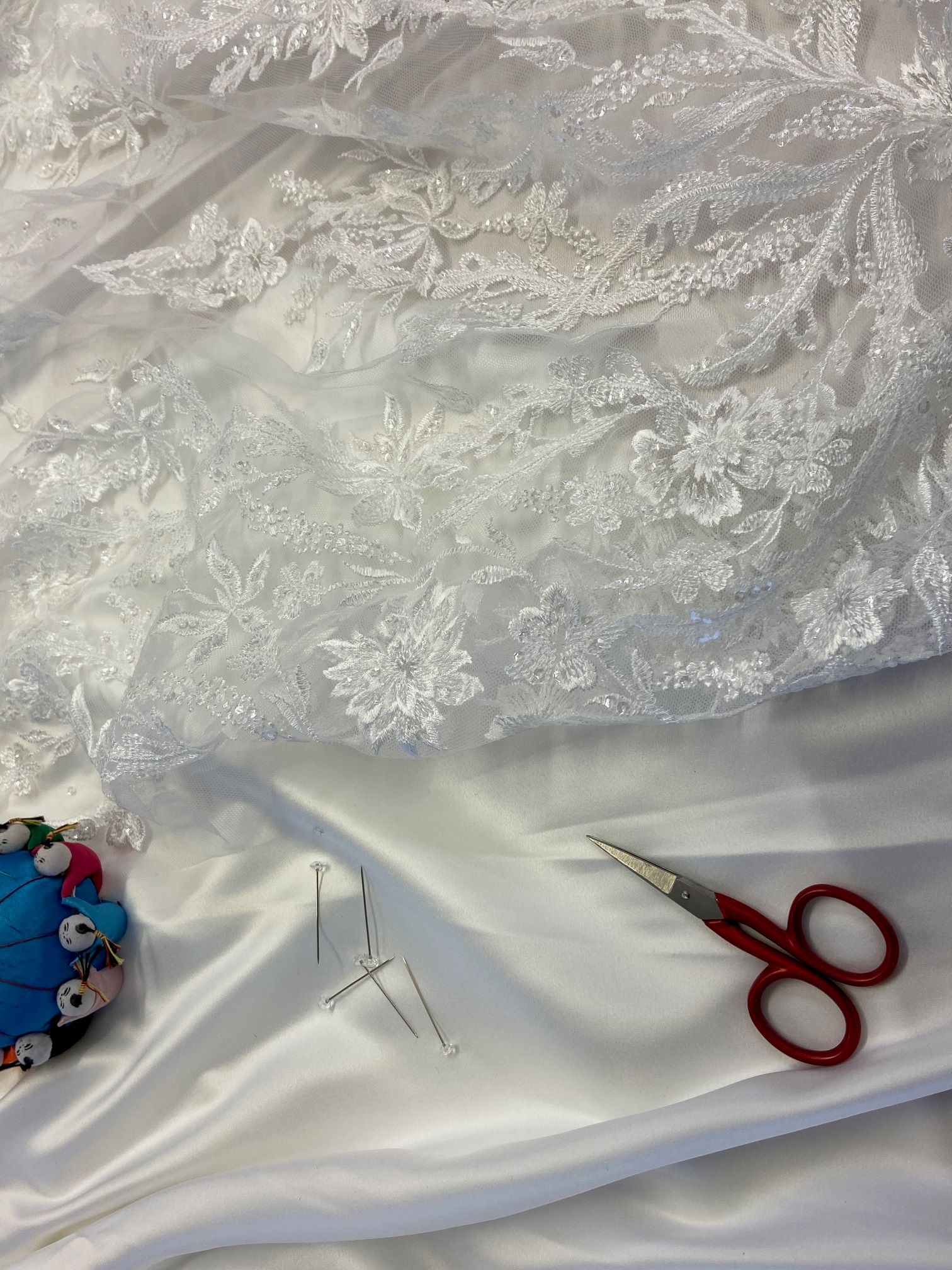 Eine Schere liegt auf einem weißen Tuch.