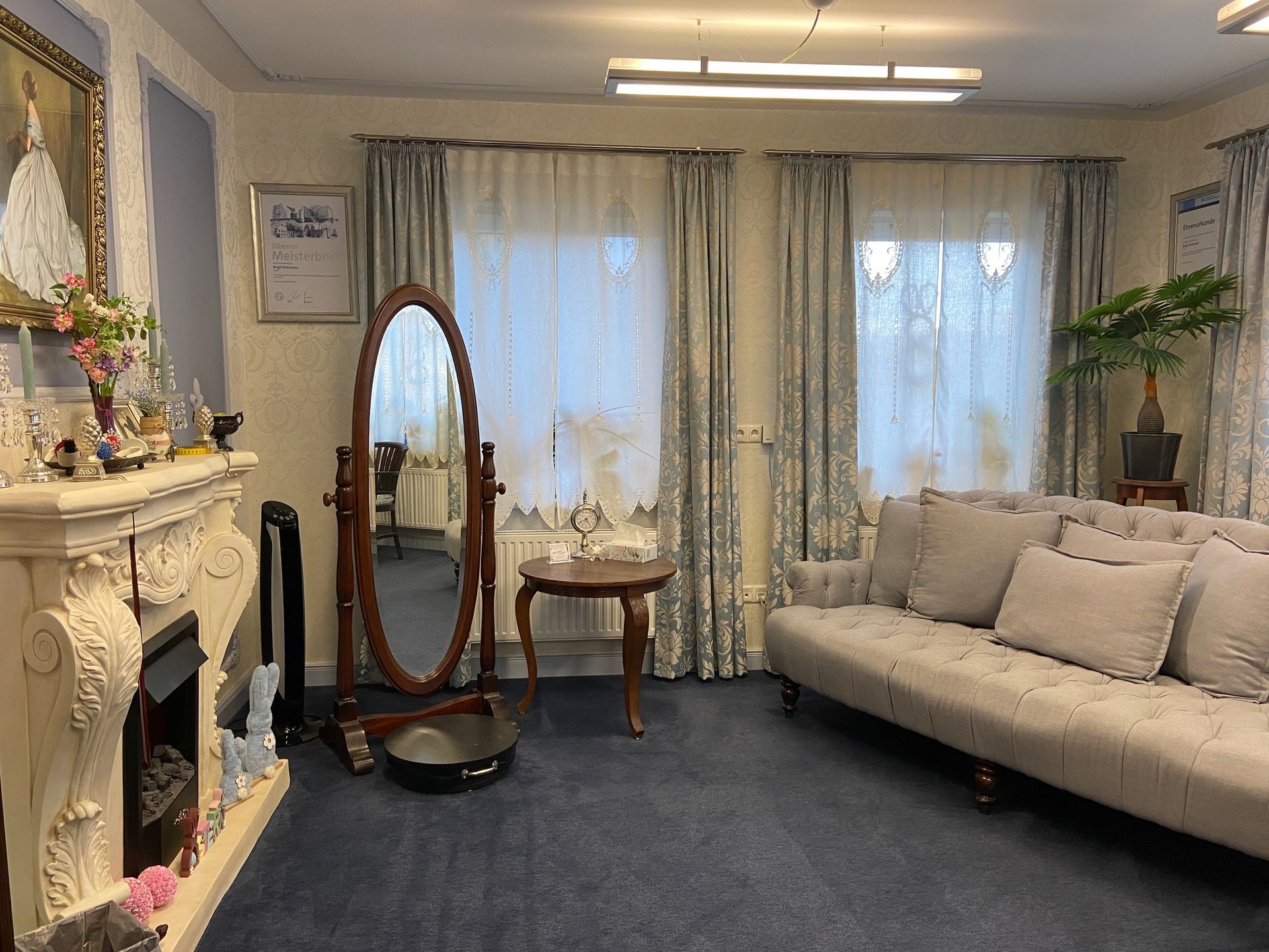 Ein Wohnzimmer mit Couch, Kamin, Spiegel und Tisch.