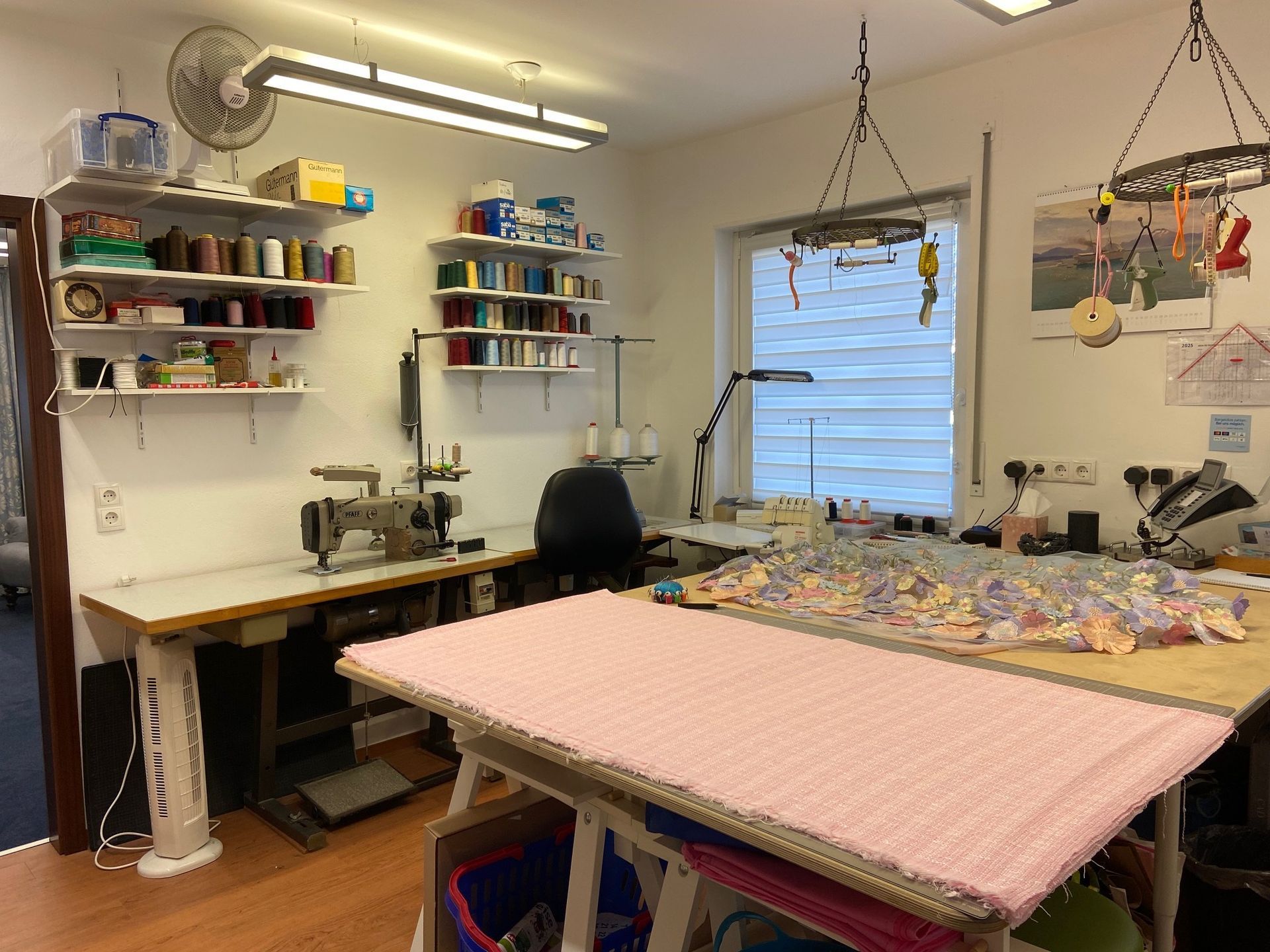 Ein Nähzimmer mit einem großen Tisch und einer Nähmaschine.