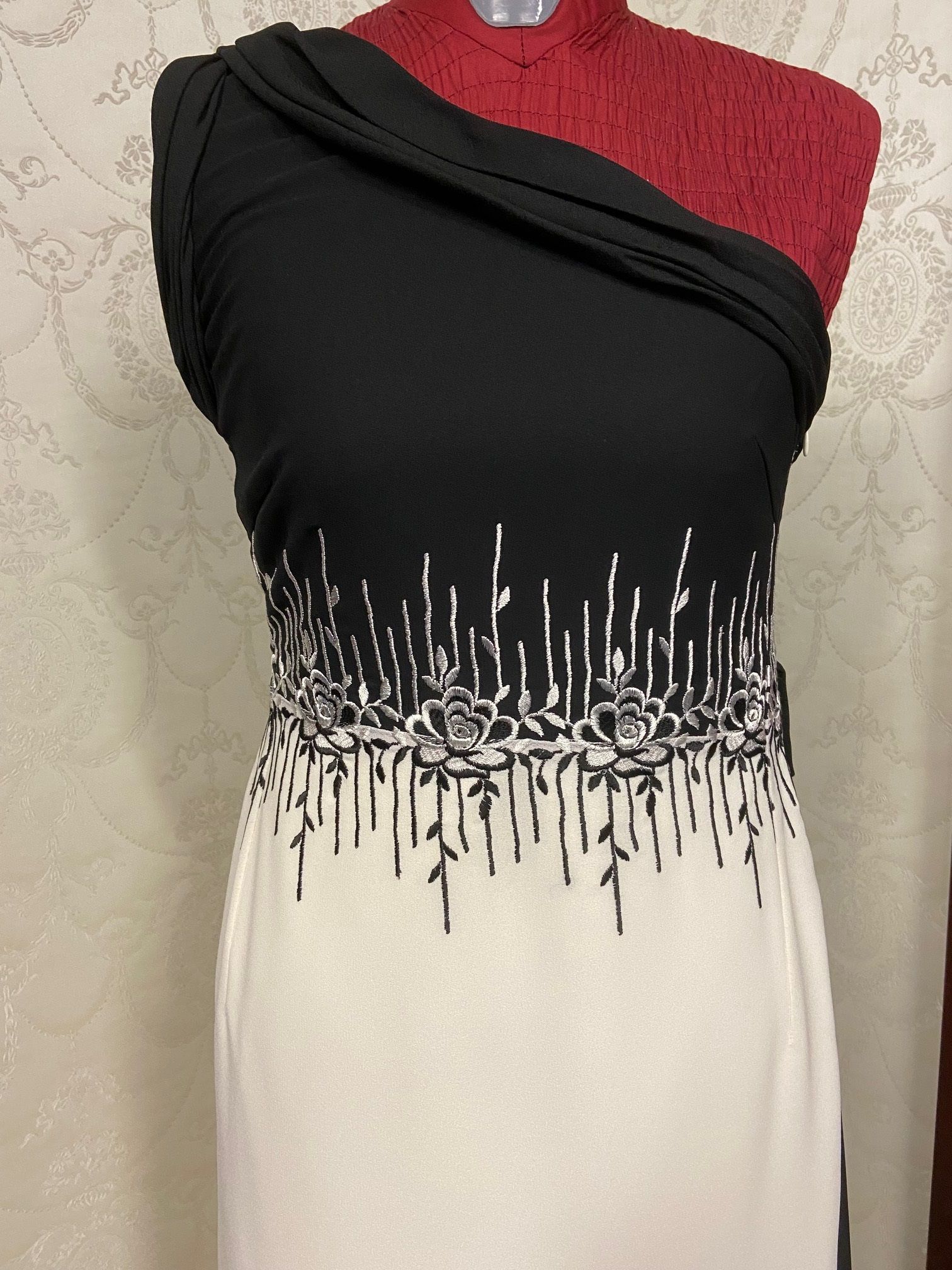 Ein schwarz-weißes Kleid hängt an einer Schaufensterpuppe