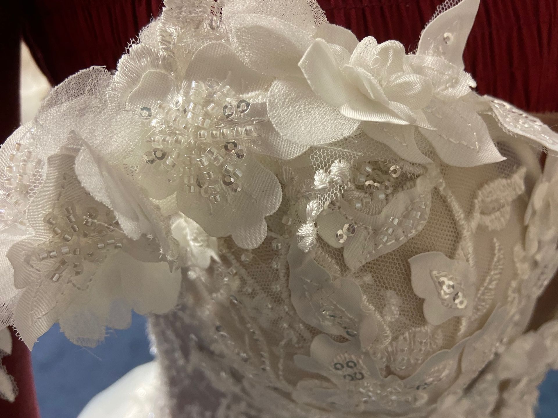 Eine Nahaufnahme eines Brautkleides mit Blumen darauf.