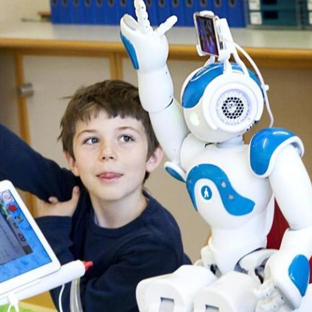 A boy sitting next to a robot that has the number 4 on it