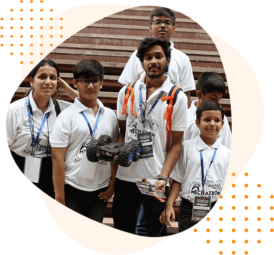 A group of young people standing next to each other holding remote controlled cars.