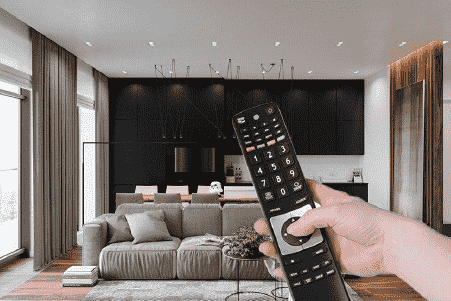 A person is holding a remote control in a living room.