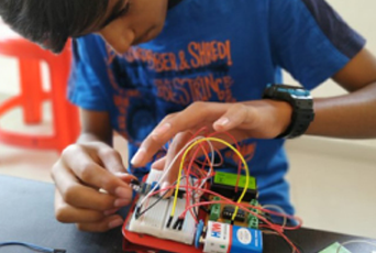 A boy in a blue shirt is working on a project