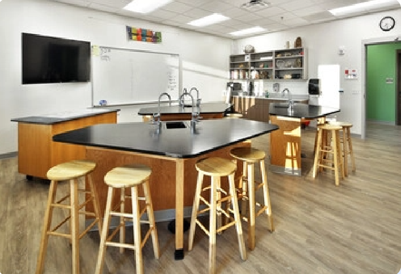 A classroom with a lot of tables and stools