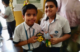 Two young boys in school uniforms are posing for a picture