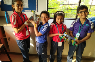 A group of children are standing next to each other in a room holding toys.