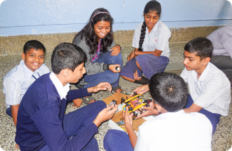 A group of children are sitting on the floor playing with toys