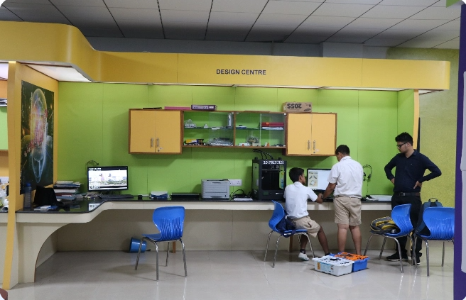 A group of people are working on computers in a room with green walls