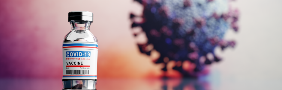 A close up of a bottle of vaccine with a virus in the background.