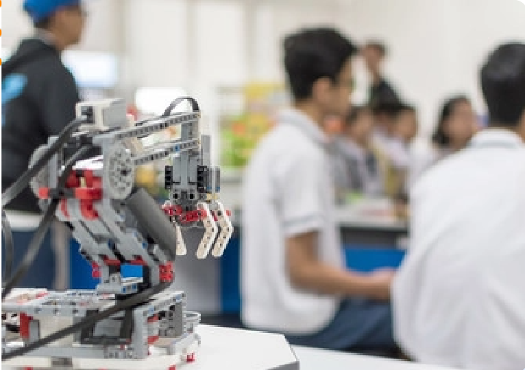 A group of people are sitting around a table with a robot on it.