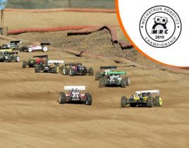 A group of rc cars are racing on a dirt track.