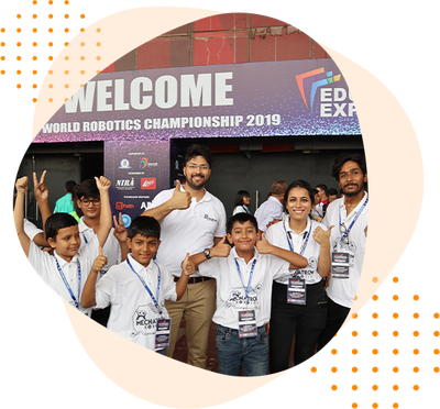 A group of people are posing for a picture in front of a welcome sign.