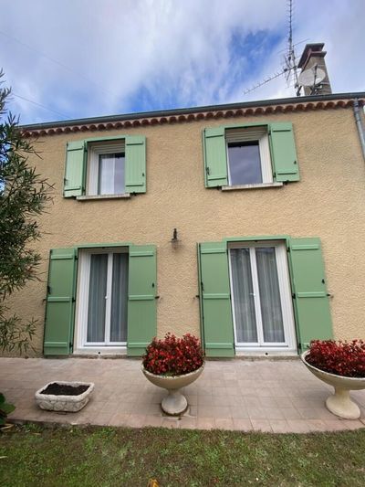 Façade d'une maison avec volets battants verts.