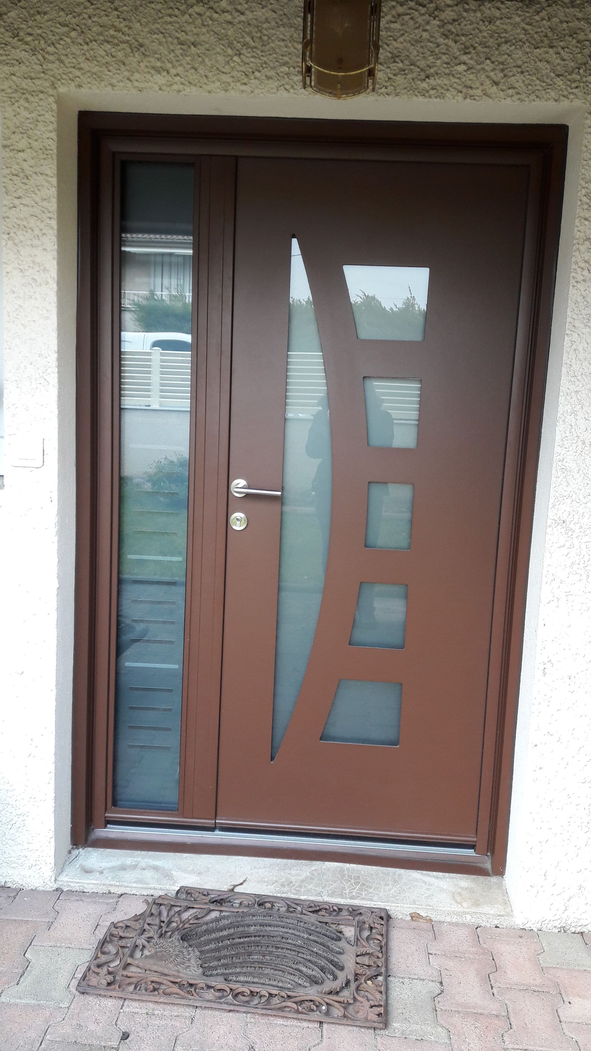 Une porte d'entrée moderne marron avec un panneau latéral vitré et cinq découpes rectangulaires distinctes en verre dépoli.