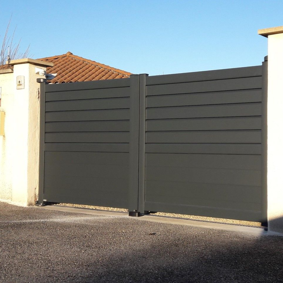 Un portail double moderne, gris foncé, avec des lames horizontales, installé entre deux piliers en maçonnerie couleur crème.