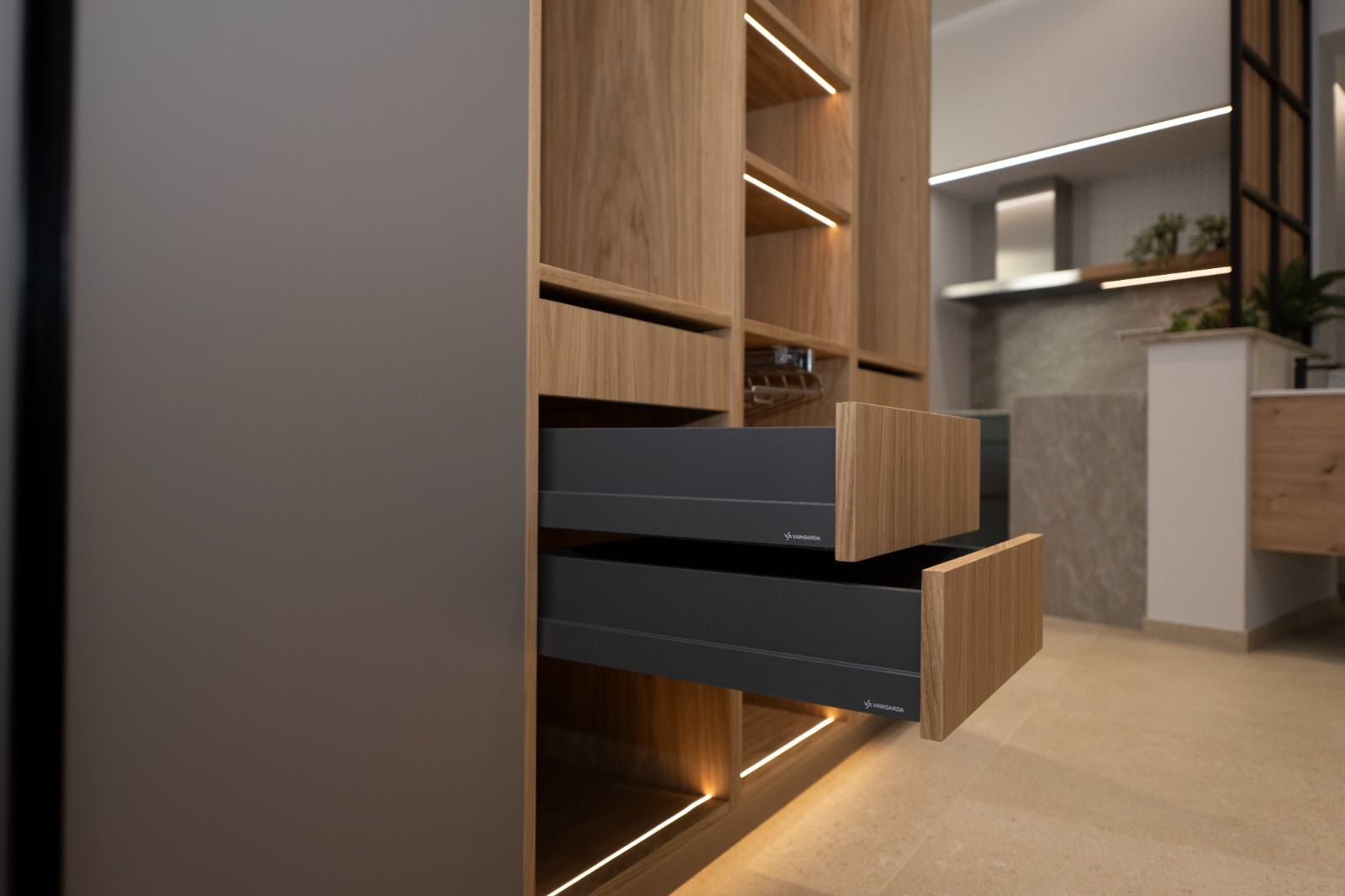 Mueble de madera con cajones abiertos, iluminación integrada y una mirada a una cocina moderna.