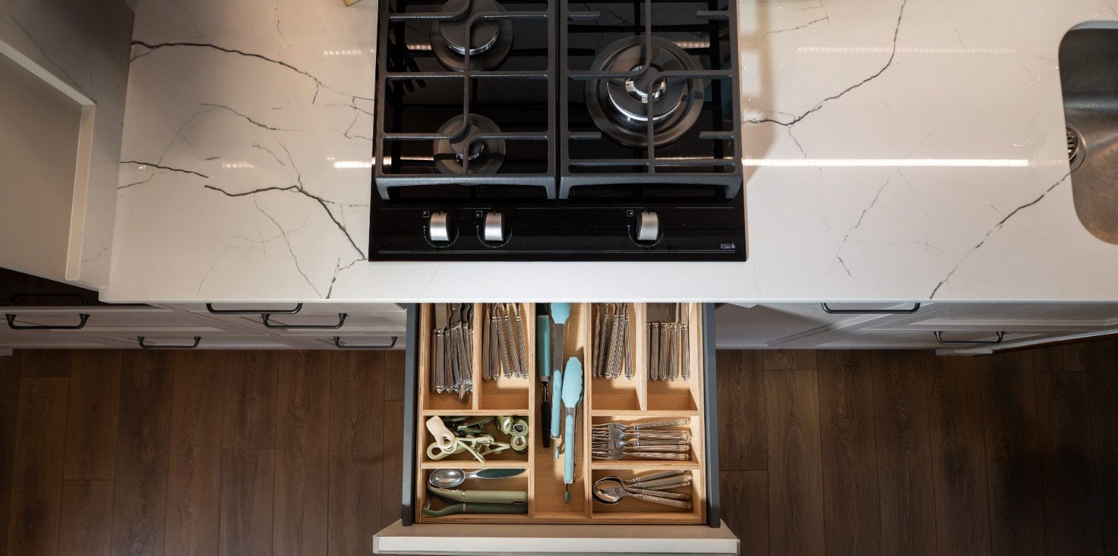Vista aérea de la estufa de la cocina con un cajón de cubiertos extraído debajo.