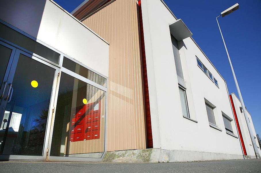 Entrée d'une résidence avec des boites aux lettres rouge