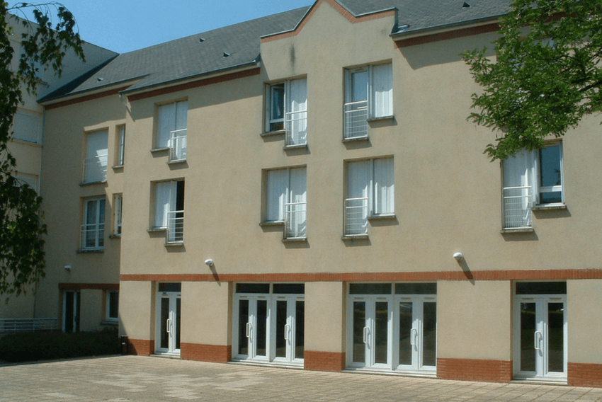 Façade d'un bâtiment avec plusieurs portes d'entrée et fenêtres