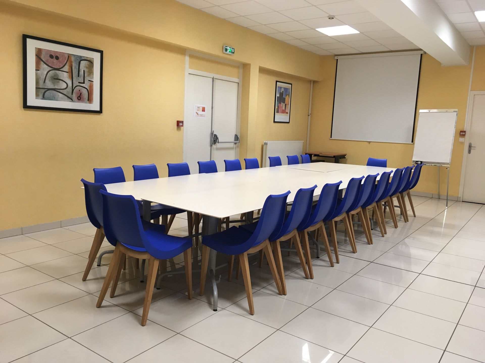Salle de travail avec table réctangulaire et chaises bleu