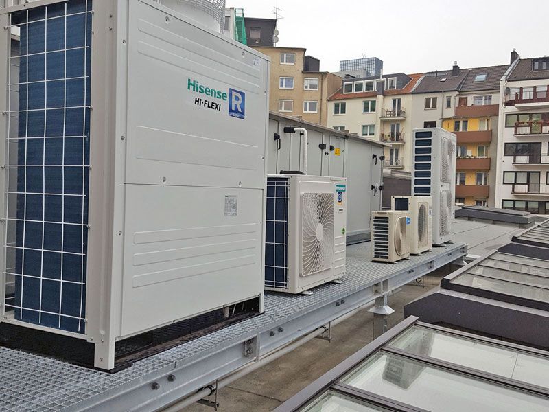Auf dem Dach eines Gebäudes steht eine Reihe von Klimaanlagen.