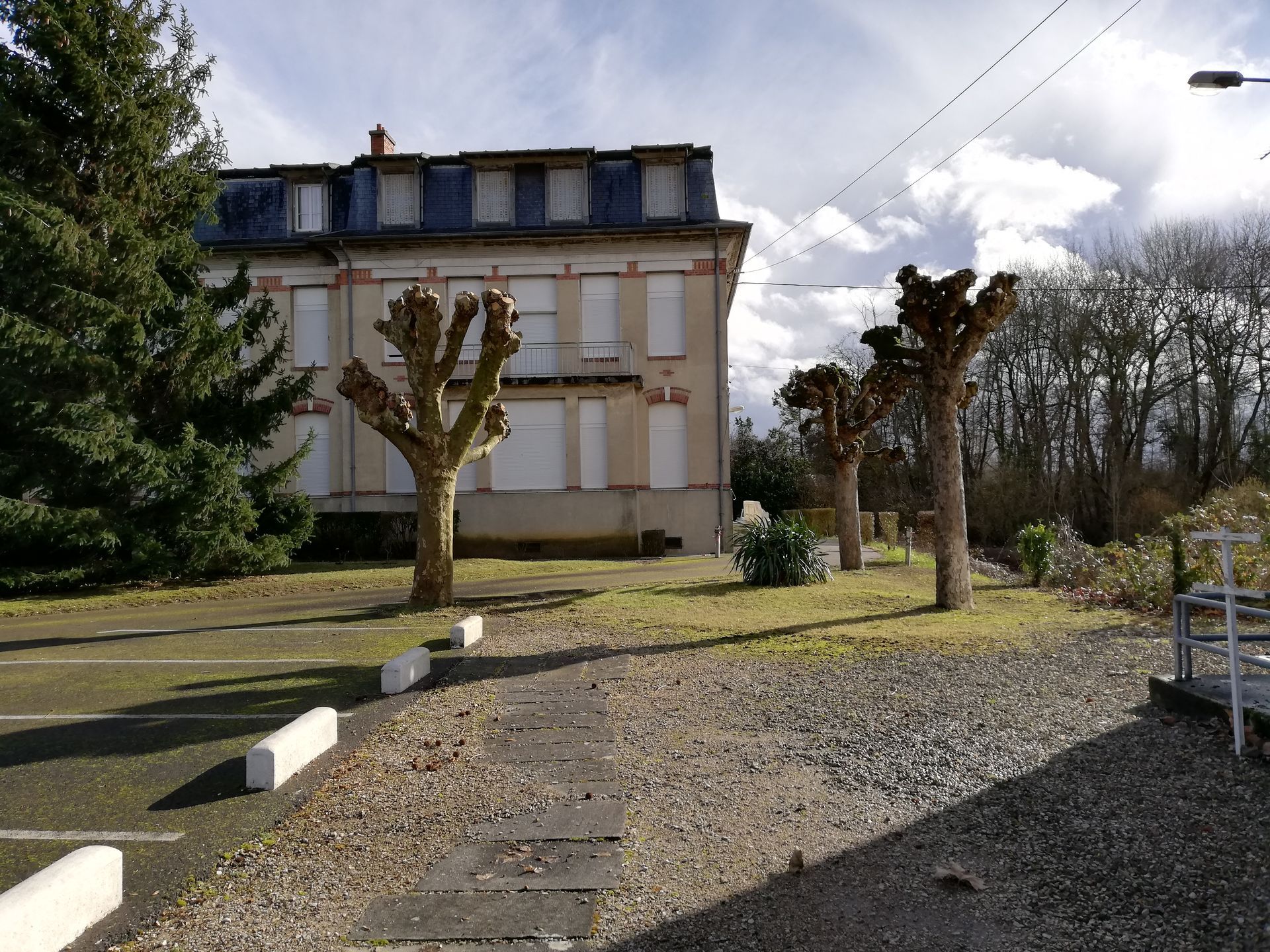 Un petit parking avec des arbres élagués