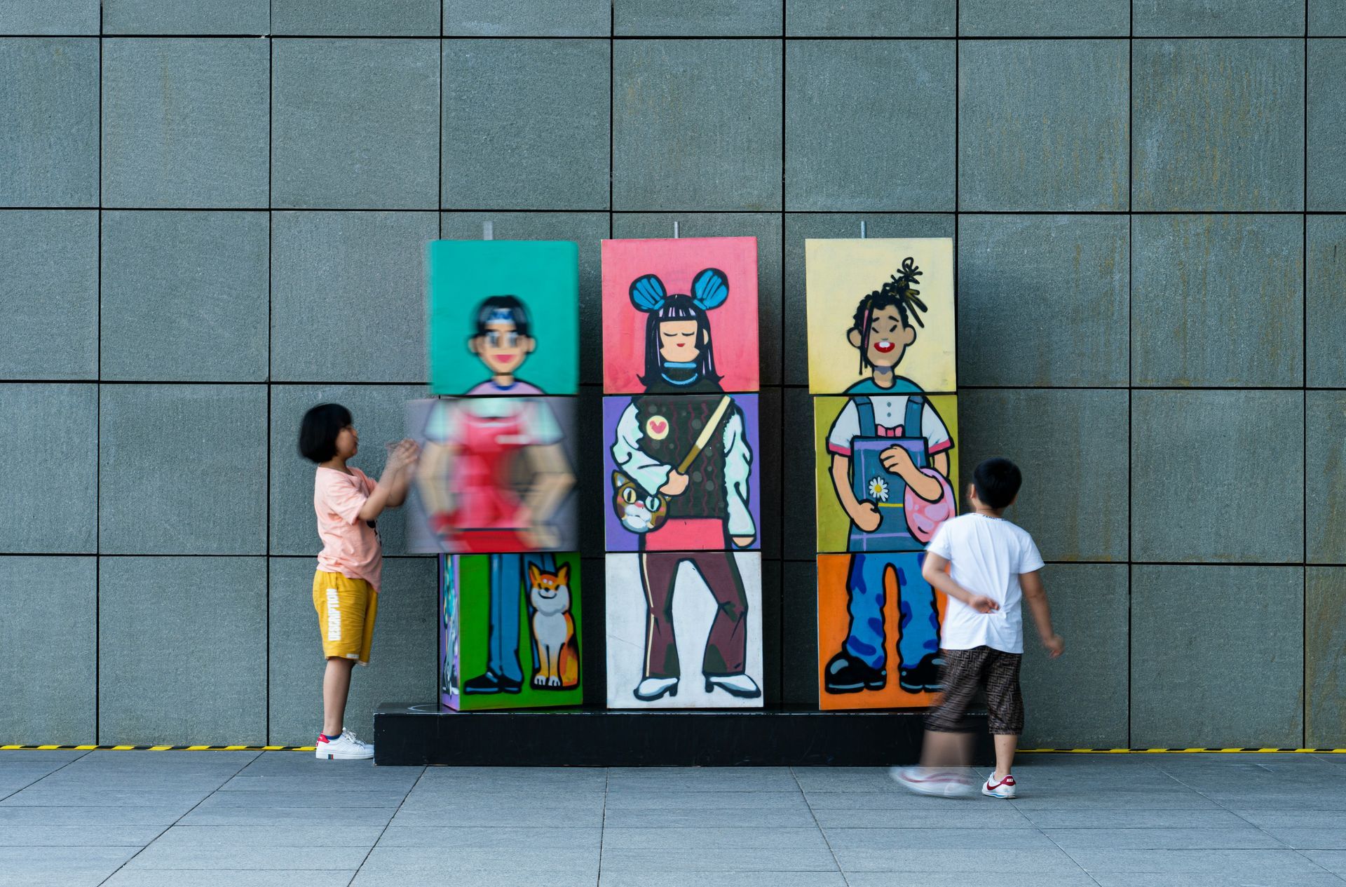 Drehbausteine mit unterschiedlichen Gesichtern, Oberkörpern und Beinen, welche von zwei Kindern gedreht werden.