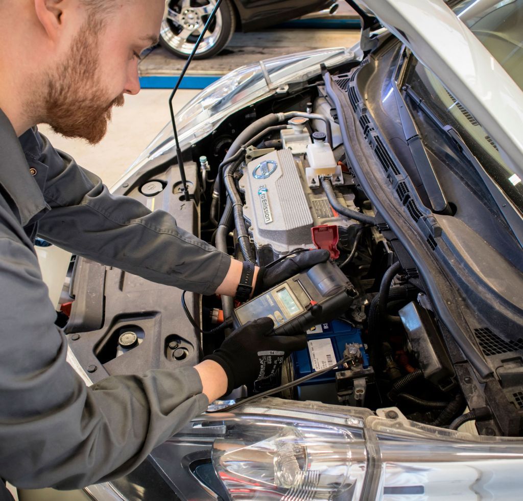 Sebastian Alasmäki
Mekaanikko työskentelee auton konepellin alla diagnostiikkatyökalun kanssa autokorjaamolla