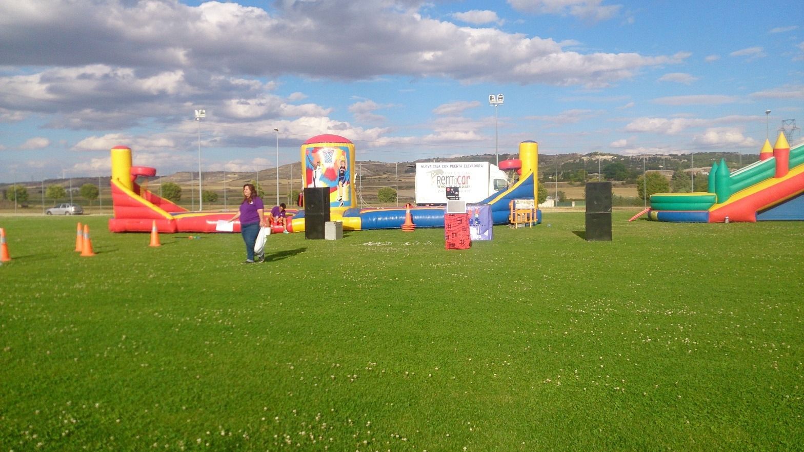 Una mujer está parada en un campo con un montón de casas inflables.