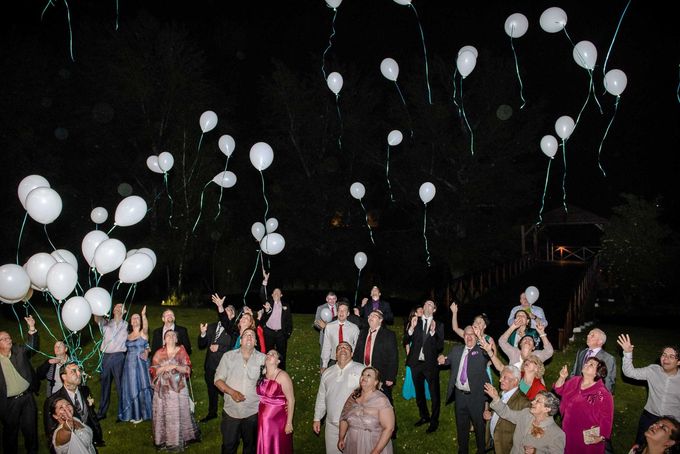 Un grupo de personas está lanzando globos blancos al aire.