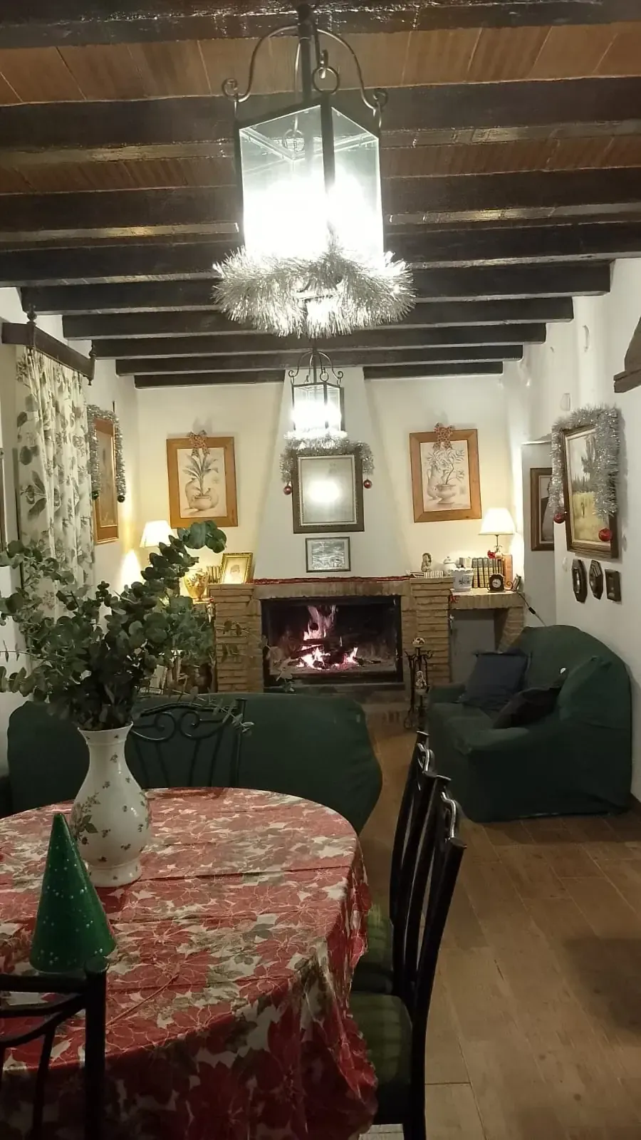 Acogedor comedor con chimenea, farole encendido y decoración festiva.